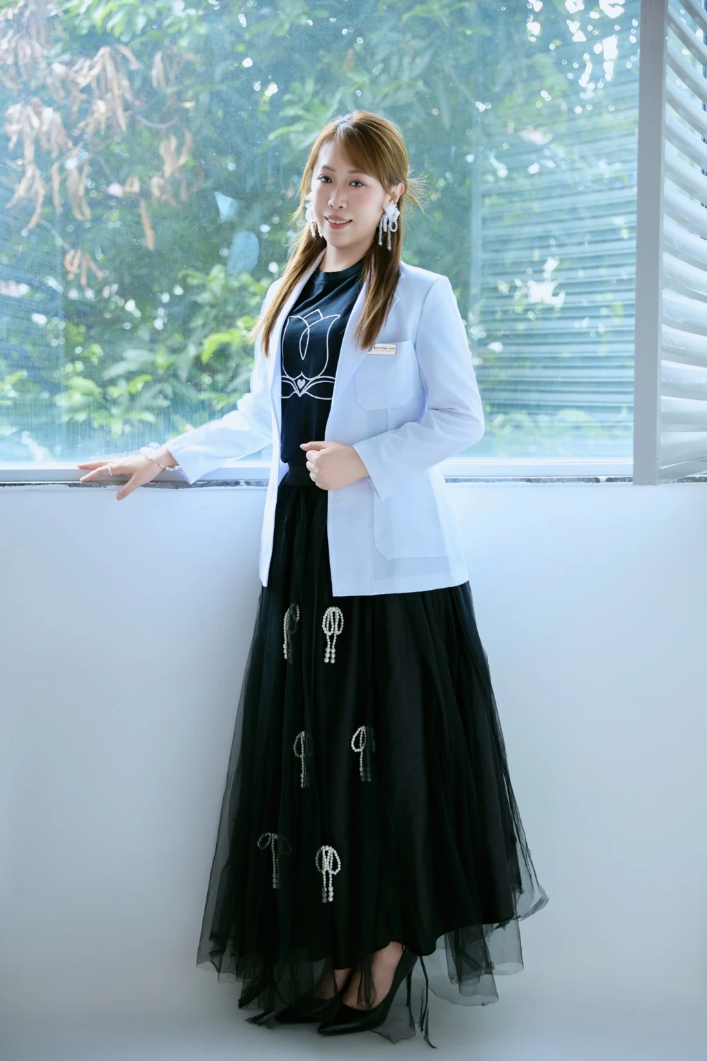婷婷穿著白色外套站在窗邊的本人形象照